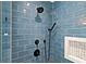 Bathroom shower showcasing blue tiled walls, black fixtures, and a built-in shower niche at 3019 Haverford Se Ln, Marietta, GA 30067