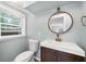 Bathroom with modern sink, faucet, wood cabinet and large round mirror at 3019 Haverford Se Ln, Marietta, GA 30067
