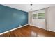 Cozy bedroom featuring hardwood floors, a contemporary light fixture and soothing blue accent wall at 3019 Haverford Se Ln, Marietta, GA 30067