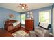 Charming Bedroom includes a wooden crib, dresser, and a cozy armchair, all set against blue walls at 49 Timberlake Ne Cv, Cartersville, GA 30121