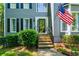 Close-up of a charming front entrance with a brick stairway, black trimmed door, and tidy landscaping at 49 Timberlake Ne Cv, Cartersville, GA 30121