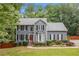 Charming two-story home with gray siding, black shutters, manicured lawn, and a welcoming front entrance at 49 Timberlake Ne Cv, Cartersville, GA 30121
