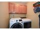 Functional laundry area with modern washer and dryer units and overhead storage cabinets at 49 Timberlake Ne Cv, Cartersville, GA 30121