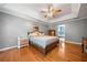 Serene main bedroom featuring hardwood floors, a ceiling fan, tray ceilings, and access to the ensuite bathroom at 49 Timberlake Ne Cv, Cartersville, GA 30121