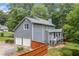 Rear exterior features a two-car garage, screened porch and deck overlooking a wooded lot at 49 Timberlake Ne Cv, Cartersville, GA 30121