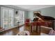 Cozy living room with hardwood floors, shuttered windows, and elegant accents including a grand piano at 530 Veranda Ct, Alpharetta, GA 30009