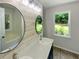 Bathroom featuring new vanities and an oval mirror at 575 Freeman Dr, Covington, GA 30016