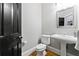 Charming powder room with hardwood floors, white pedestal sink, and a striking black door at 1255 Beech Haven Ne Rd, Atlanta, GA 30324