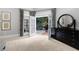 Bright bedroom featuring neutral walls, double doors to deck, and a dark wood dresser with round mirror at 1255 Beech Haven Ne Rd, Atlanta, GA 30324