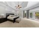 Spacious bedroom featuring a tray ceiling, ceiling fan, and doors to the outdoor area at 1255 Beech Haven Ne Rd, Atlanta, GA 30324