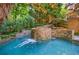 Beautiful pool with waterfall feature surrounded by lush landscaping and trees at 1255 Beech Haven Ne Rd, Atlanta, GA 30324