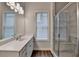 Bright bathroom featuring a quartz countertop, wood floor, and glass-enclosed shower with white marble style tile at 2505 Whistler Way Ne, Lawrenceville, GA 30043