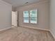 Light bedroom with neutral carpet, a window and open door to the bathroom at 2505 Whistler Way Ne, Lawrenceville, GA 30043