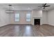 Open-concept living room with dark wood floors, fireplace, and modern chandelier at 2505 Whistler Way Ne, Lawrenceville, GA 30043