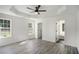 Spacious bedroom with tray ceiling, ceiling fan, and a doorway leading to an en suite bathroom at 267 Rocky Point Rd, Covington, GA 30014
