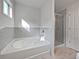 Bright bathroom featuring a tub, tiled wall, and glass-enclosed shower at 44 Trailview Ln # 78, Hiram, GA 30141