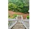 View down outdoor wooden steps surrounded by lush greenery and landscaping at 104 Abingdon Way, Atlanta, GA 30328