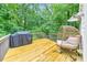 Back deck with grill and outdoor seating overlooking the beautiful wooded backyard at 138 Hartwood Dr, Woodstock, GA 30189
