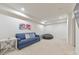 View of the finished basement with a comfortable blue couch and a modern painting of horses at 138 Hartwood Dr, Woodstock, GA 30189