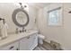 Light and bright bathroom showcasing a single sink, rounded mirror, toilet, and patterned flooring at 138 Hartwood Dr, Woodstock, GA 30189