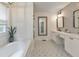 Bright bathroom featuring double sinks, vanity, modern mirrors, and a decorative tiled accent wall at 138 Hartwood Dr, Woodstock, GA 30189