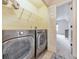 Laundry room area with large gray washer and dryer units next to an open doorway at 138 Hartwood Dr, Woodstock, GA 30189