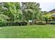 Large backyard featuring a play structure nestled amongst trees with a well-manicured lawn at 1486 Maple Ridge Dr, Suwanee, GA 30024