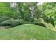 Secluded backyard featuring lush greenery, mature trees, and a well-maintained lawn at 1486 Maple Ridge Dr, Suwanee, GA 30024