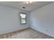 Minimalist bedroom with a single window, neutral carpet, and white walls, offering a blank canvas for personalization at 1486 Maple Ridge Dr, Suwanee, GA 30024