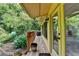 Cozy covered porch with greenery, potted plants, grill, and doorway at 1486 Maple Ridge Dr, Suwanee, GA 30024
