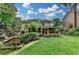 Yellow house backyard with stairs to patio and deck with lush landscaping at 1486 Maple Ridge Dr, Suwanee, GA 30024