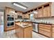 Well-equipped kitchen with light wood cabinets, an island, and stainless steel appliances at 1486 Maple Ridge Dr, Suwanee, GA 30024