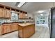 Bright kitchen features wood cabinets, black countertops, and a center island at 1486 Maple Ridge Dr, Suwanee, GA 30024