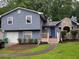 Charming two-story home with blue siding, stone accents, and a well-maintained front yard at 604 Pepperwood Ln, Stone Mountain, GA 30087