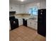 Functional kitchen featuring white cabinets, black appliances, and tile flooring at 604 Pepperwood Ln, Stone Mountain, GA 30087