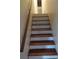 Wooden staircase with white risers and a handrail, leading to the upper level at 604 Pepperwood Ln, Stone Mountain, GA 30087