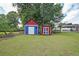 Spacious backyard featuring two colorful storage sheds, enhancing outdoor living and storage solutions at 629 Birchwood Rd, Marietta, GA 30060