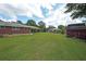 Spacious backyard with lush lawn, brick house, covered carport, and storage shed in a residential setting at 629 Birchwood Rd, Marietta, GA 30060