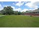 Expansive backyard features a lush green lawn, mature trees, and a view of the brick home at 629 Birchwood Rd, Marietta, GA 30060