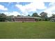 Exterior view of a brick home with an expansive green lawn and a covered patio in the backyard at 629 Birchwood Rd, Marietta, GA 30060