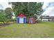 Two colorful backyard sheds offer outdoor storage solutions on a grassy lawn at 629 Birchwood Rd, Marietta, GA 30060