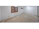 Unfinished basement features white walls and carpet, complemented by a wooden window frame at 629 Birchwood Rd, Marietta, GA 30060