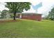 Charming brick home featuring a large front yard, carport, and inviting front entrance at 629 Birchwood Rd, Marietta, GA 30060