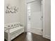 Hallway with hardwood floors, white storage bench, and view into a carpeted room at 631 Avondale Creek Dr, Decatur, GA 30032