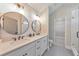 Bathroom featuring double sinks, round mirrors, shiplap walls, and a glass shower at 4230 Old Cherokee St, Acworth, GA 30101
