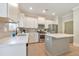 Bright kitchen features white cabinets, stainless steel appliances, backsplash and a center island with light hardwood floors at 4230 Old Cherokee St, Acworth, GA 30101