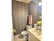 Cozy half-bathroom featuring floral wallpaper and vanity at 4855 West Price Rd, Sugar Hill, GA 30518