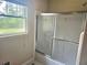 Bathroom features a window, vanity, and frosted glass shower door at 4855 West Price Rd, Sugar Hill, GA 30518