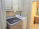 Laundry room with washer, dryer, storage cabinets, and access to sink at 4855 West Price Rd, Sugar Hill, GA 30518