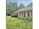 Side view of brick home showcasing manicured lawn and mature landscaping at 4855 West Price Rd, Sugar Hill, GA 30518